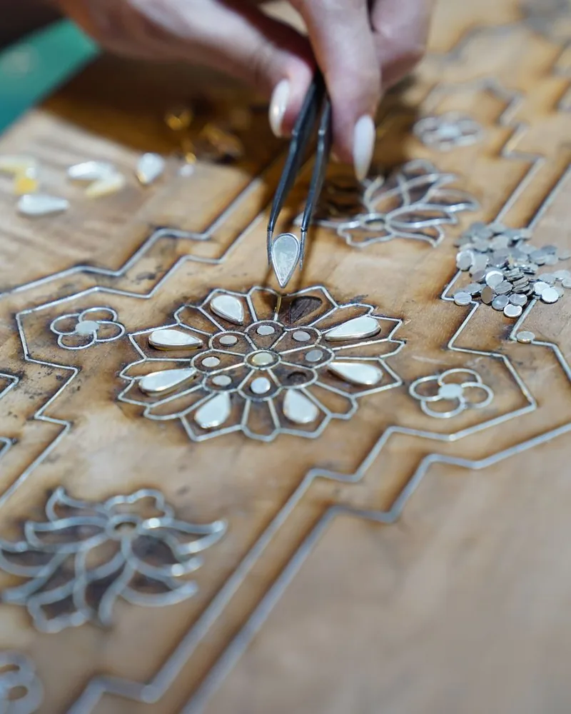 Detalle de una composición de marquetería floral con piezas pequeñas de chapa colocadas con pinzas